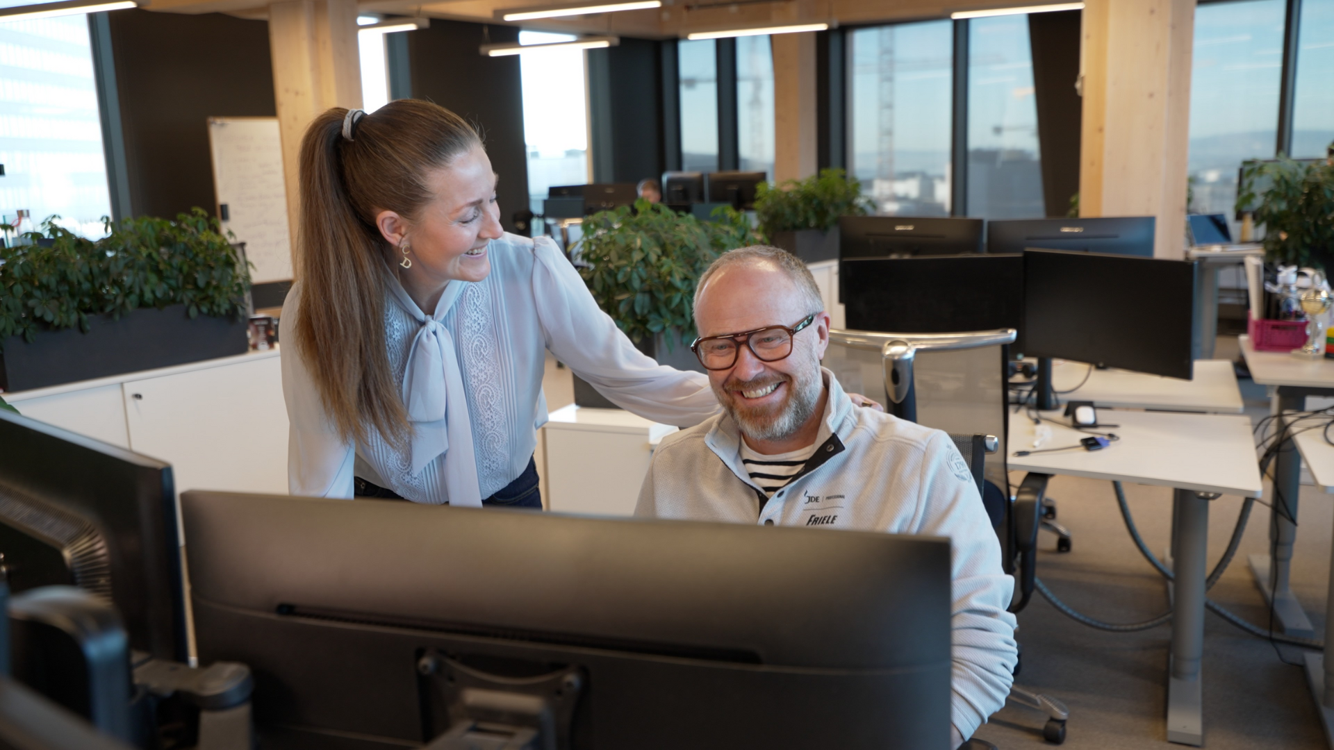 To mennesker ved en datamaskin som ser på dataskjermen